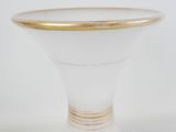 a white vase with a gold rim sitting on a table