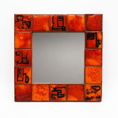 orange and brown mosaic mirror with black writing on it