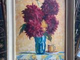 a painting of flowers in a blue vase on a easel