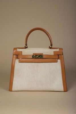 une photo d'un sac à main blanc et beige muni d'une poignée marron