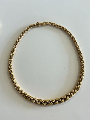 a close up of a gold necklace on a white surface