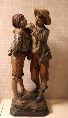 une statue représentant deux garçons debout l'un à côté de l'autre