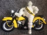 une figurine représentant un homme assis sur une moto jaune