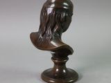 bronze bust of a woman with long hair on a pedestal