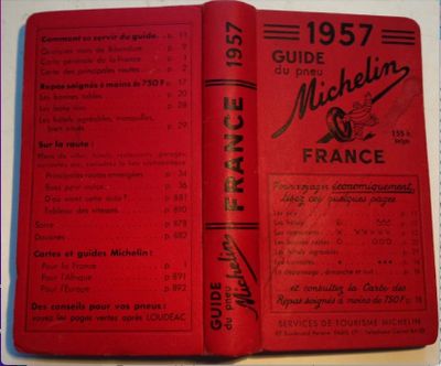 un livre ouvert, à la couverture rouge, posé sur une table