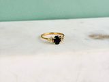 Gros plan sur une bague en or ornée d'une pierre noire