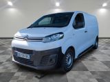 la camionnette blanche est garée dans une grande pièce au sol en damier