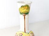 un vase blanc orné d'un arbre, posé sur une table