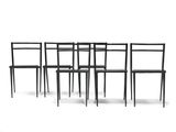 quatre chaises noires placées les unes à côté des autres sur une surface blanche