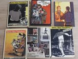 six books on a wooden table with one of them being a comic