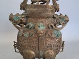 an old bronze urn with two lions on top of it