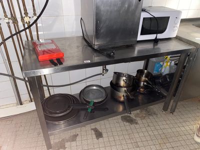 un micro-ondes posé sur une table en acier inoxydable