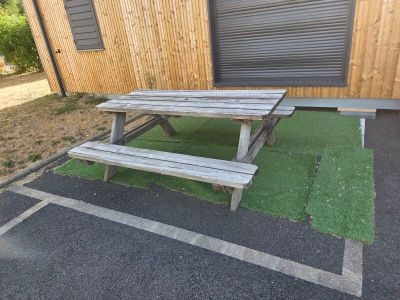 une table de pique-nique et un banc devant un immeuble