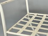 a white metal chair with a woven seat on a gray background