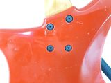 a close up of a red electric guitar with blue buttons