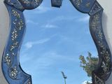 un miroir accroché au mur, avec le ciel en arrière-plan
