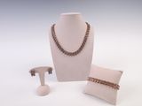 Trois bijoux sont exposés sur un mannequin blanc