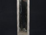 un miroir en argent richement décoré, monté sur un socle en bois, sur fond noir