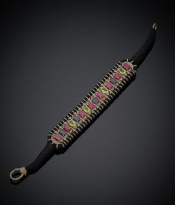 un gros plan sur un bracelet noir orné de pierres roses et vertes