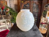 a white vase sitting on top of a wooden table