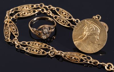 un gros plan sur un collier en or orné d'une pièce et d'une bague
