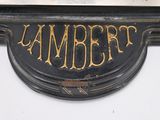 a black and gold sign that says lambert on it
