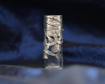 a glass bottle that has a silver design on it