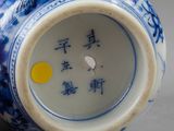 a blue and white vase with chinese writing on it