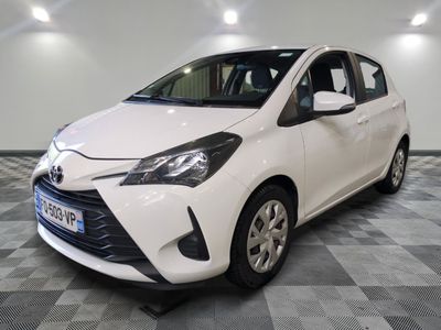 the toyota yaris is parked in a clean room with a checkered floor