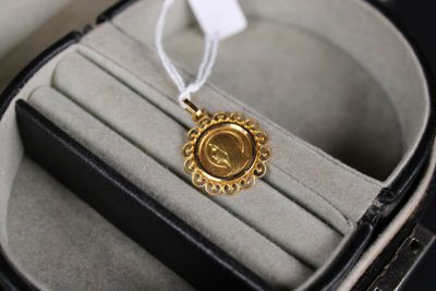 une médaille d'or dans un écrin orné d'un ruban blanc
