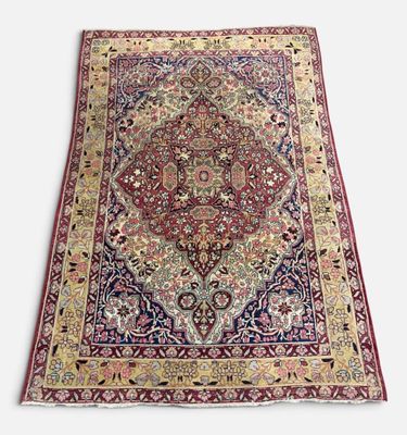 un tapis persan antique avec un motif floral sur fond blanc