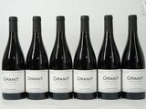 six bouteilles de vin sont alignées sur une table