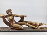 bronze sculpture of a woman reclining on a chair with a dog