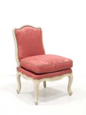 une chaise rembourrée avec un coussin rose rembourré