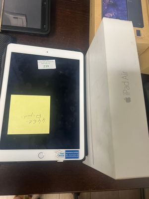 an apple ipad is sitting on a table next to a box with a sticky note on it