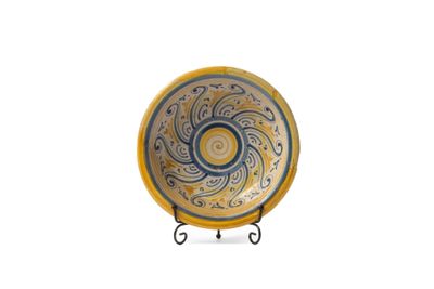 une assiette jaune et bleue ornée d'un motif en spirale
