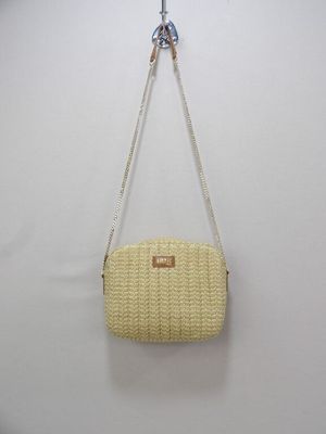 a white purse hanging on a wall with a chain