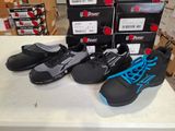 several pairs of black and blue shoes on a table in front of boxes