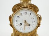 une horloge en or surmontée d'une couronne