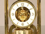 une horloge en or posée sur une table en verre
