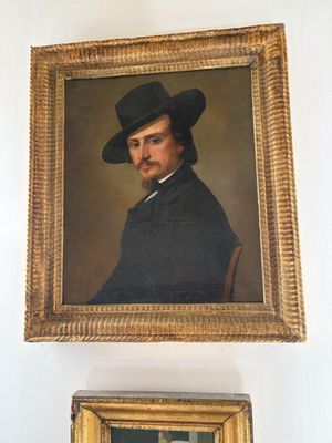 a painting of a man in a black hat and a painting of a man in a black suit