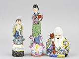 trois figurines chinoises représentant des femmes et un homme sur fond blanc