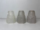 three frosted glass vases sitting on top of a white counter