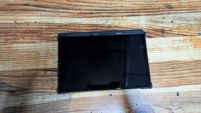 a small black tablet computer on a wooden table