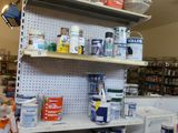 a shelf full of paint and other items in a room