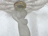 a glass vase that has a statue on top of it