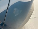 a reflection of a person standing on the side of a car