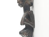 statue of a woman holding a vase on a white surface