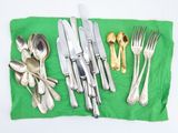 a lot of silverware on a green place mat