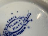 a close up of a blue and white plate with a bird on it